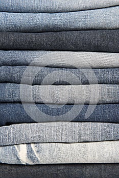 Stack of different old worn blue jeans
