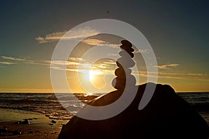 Stack of different stones in balance at the beach sunset