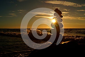 Stack of different stones in balance at the beach sunset