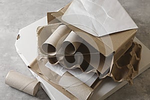 Stack of different waste paper on grey table, closeup