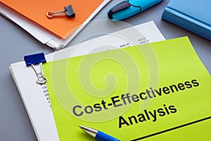 Stack of documents with cost effectiveness analysis. photo
