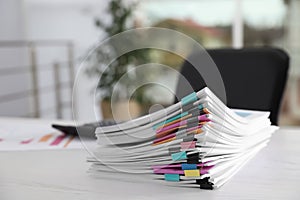 Stack of documents with paper clips on office table.