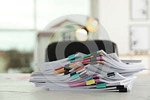 Stack of documents with paper clips on office table.