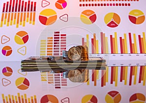 Stack Dollars  and coins at glossy surface