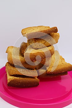 Stack of dry toast on Plastics plate. Close Up Pile of toasted bread slices. Toast loaf on white background