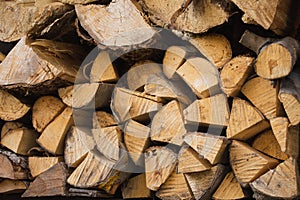 A stack of dry wood for a fireplace and a fire in the backyard