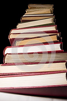 Stack of encyclopedia books over black background