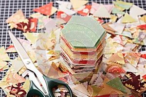 Stack english paper pieced hexagons surrounded by scraps