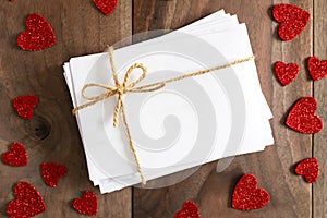 Stack of Envelopes tied with Twine Bow Surrounded by Heart Shape