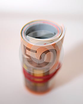 A roll of EUR european bills held with an elastic band