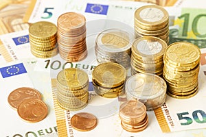 Stack of euro coins on euro banknotes, for backgrounds