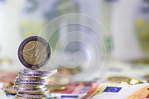 Stack of european coins and bank notes in the background show international finance with euro and europe and european trade