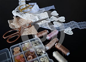 A stack of fabrics and sewing accessories on a tailor`s table