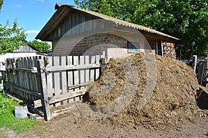 Stack of fertilizer from cow manure and straw in countryside farm. Composting Manure for organic gardening and farming.