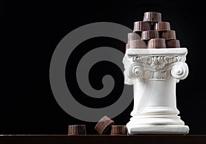 Stack of Fine Artisan Chocolates Stacked On White Pillar Column