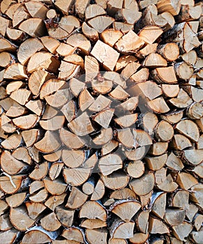 A stack of firewood, log ends, chopped birch and pine firewood. Vertical texture