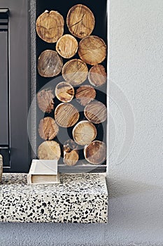 Stack of firewood logs next to fireplace in contemporary home