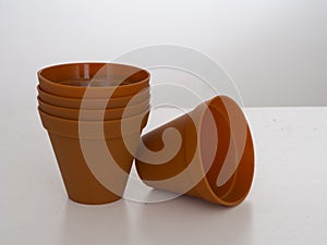 Stack of plastic flower pots on white background