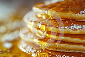 Stack of fluffy pancakes drizzled with maple syrup or honey. Close-up.