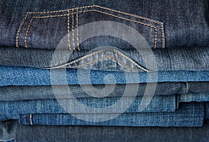 Stack of folded blue jeans pants, full frame