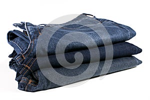 Stack of folded blue jeans on a white background