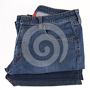 Stack of folded blue jeans on a white background