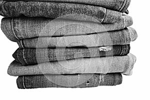 Stack of folded clothes, blue jeans pants, dark blue denim trousers on white background