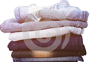 Stack of folded clothes, blue jeans pants, dark blue denim trousers on white background