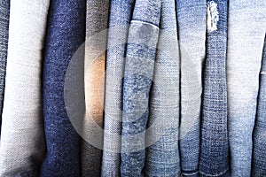 Stack of folded clothes, blue jeans pants, dark blue denim trousers on white background