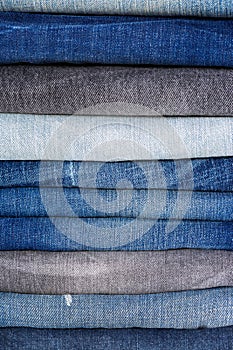 Stack of folded clothes, blue jeans pants texture, dark blue den