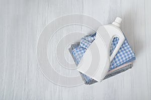 Stack of folded clothes and detergent bottle. Top view