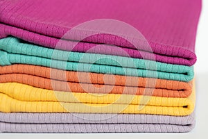 Stack folded colorful baby cotton clothing on white background isolation. Copy space. For advertising, commercial,mock