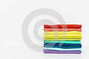 Stack of folded colorful t-shirt on white background
