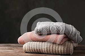Stack of folded knitted sweaters on table