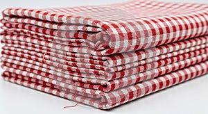 Stack of folded red and white gingham fabric isolated on white background