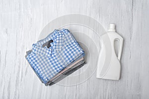 Stack of folded shirts and detergent bottle. Top view