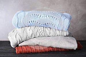 Stack of folded warm sweaters on black table