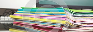 Stack of folders containing work documents in different colors