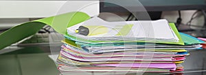 Stack of folders containing work documents in different colors