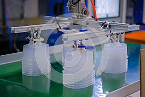 Stack of food containers on conveyor belt of plastic injection molding machine