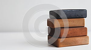 Stack of four natural soap bars in varying shades on a white background, indicating eco-friendly products