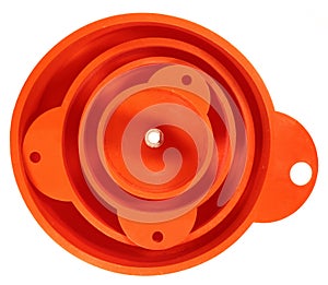 Stack of four orange plastic funnels isolated on white background.