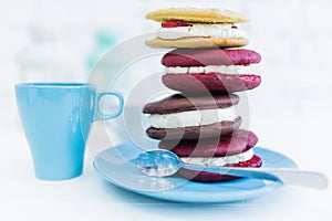 Stack of four whoopie pies or moon pies with cup and spoon.