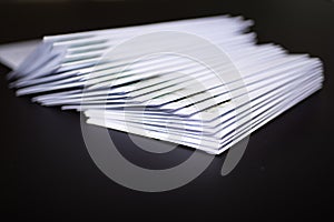 Stack of franked letters in white envelopes on black background