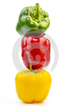 Stack of Fresh Vegetables Three Sweet Red, Yellow and Green Bell Peppers Isolated on White Background.
