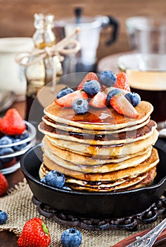 Stack of freshly prepared banana pancakes with fresh berries