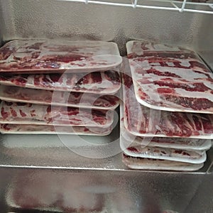 Stack of frozen sliced beef meat in frezer