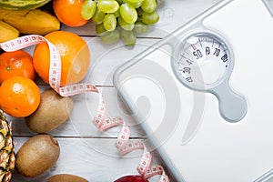 Stack of fruits, white weight scale and tailor meter