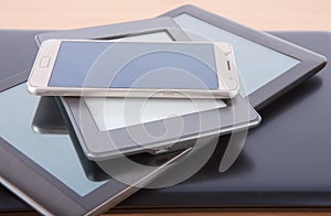 Stack of gadgets on a desk - notebook, tablet, ebook reader and