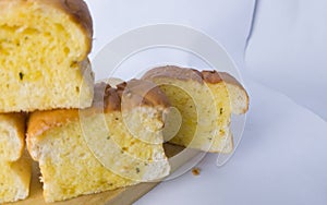stack of garlic bread on cutting board with white background